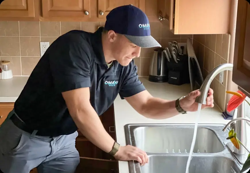 Omaha Drain plumber checking water flow at a kitchen sink faucet