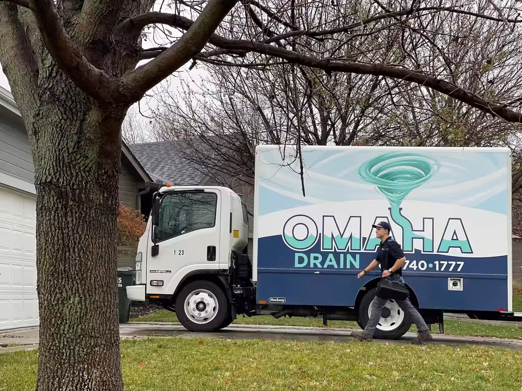 Omaha Drain plumber walking from the service truck to a home