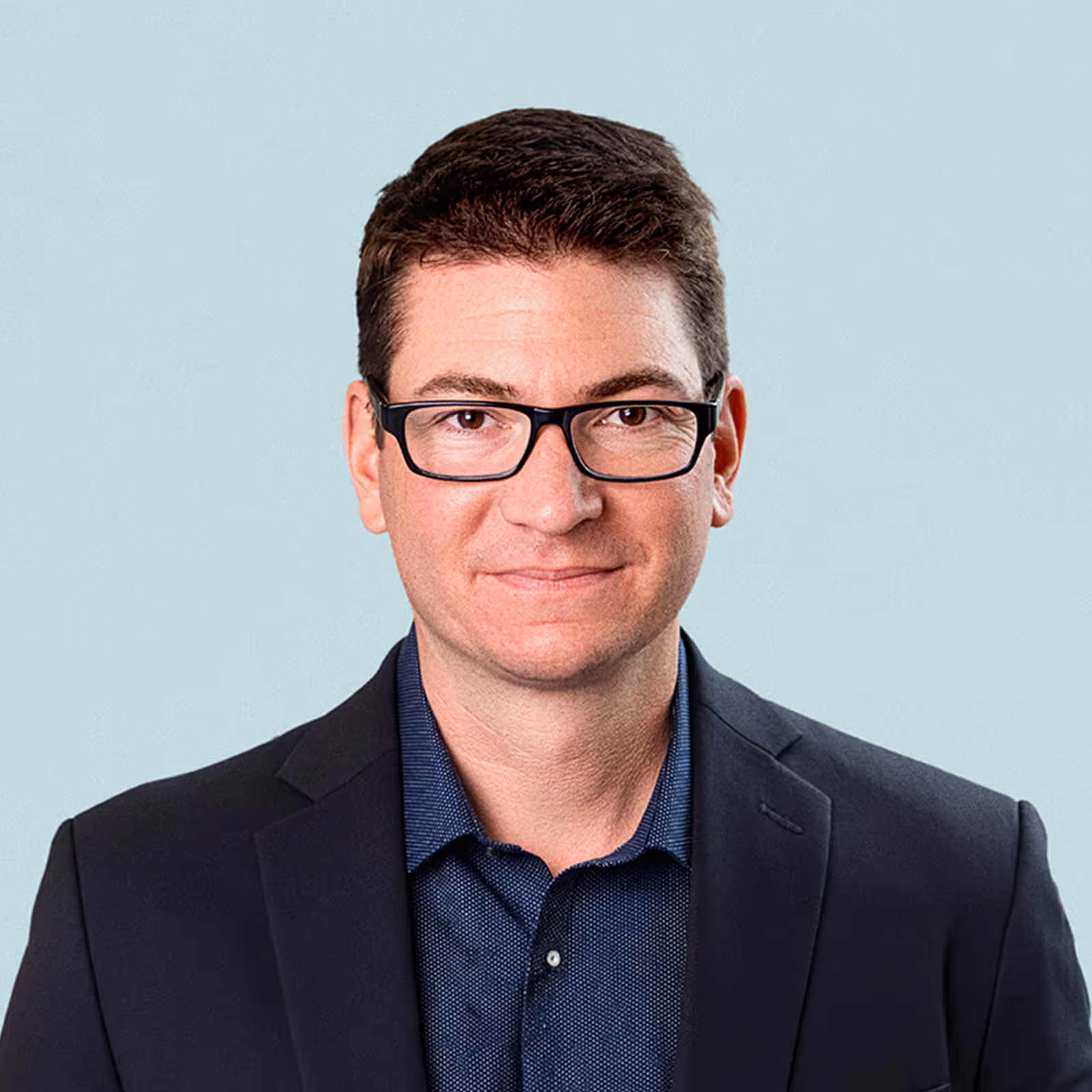 Portrait of John Schneider against a light background.