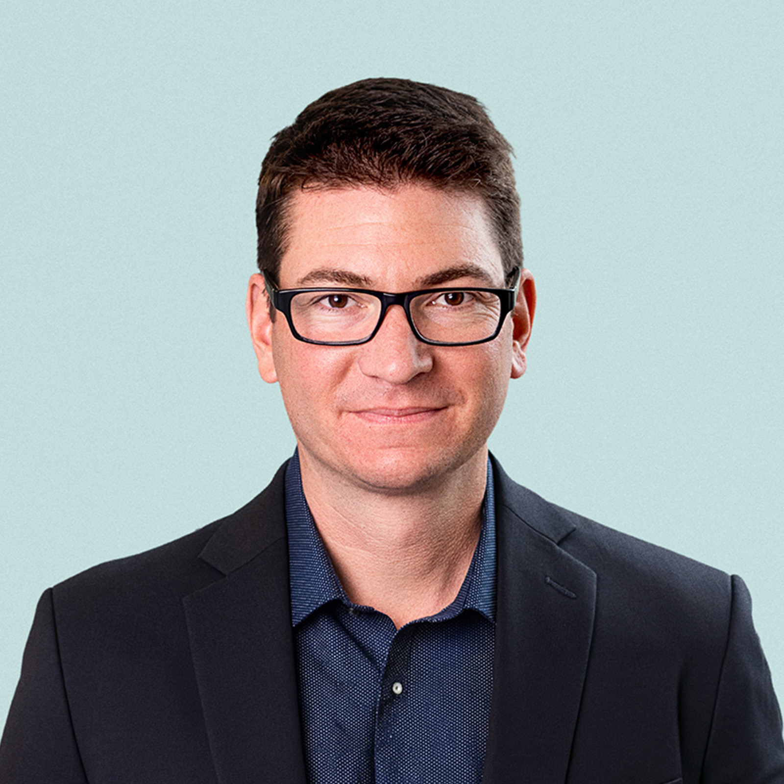 Portrait of John Schneider against a light background.