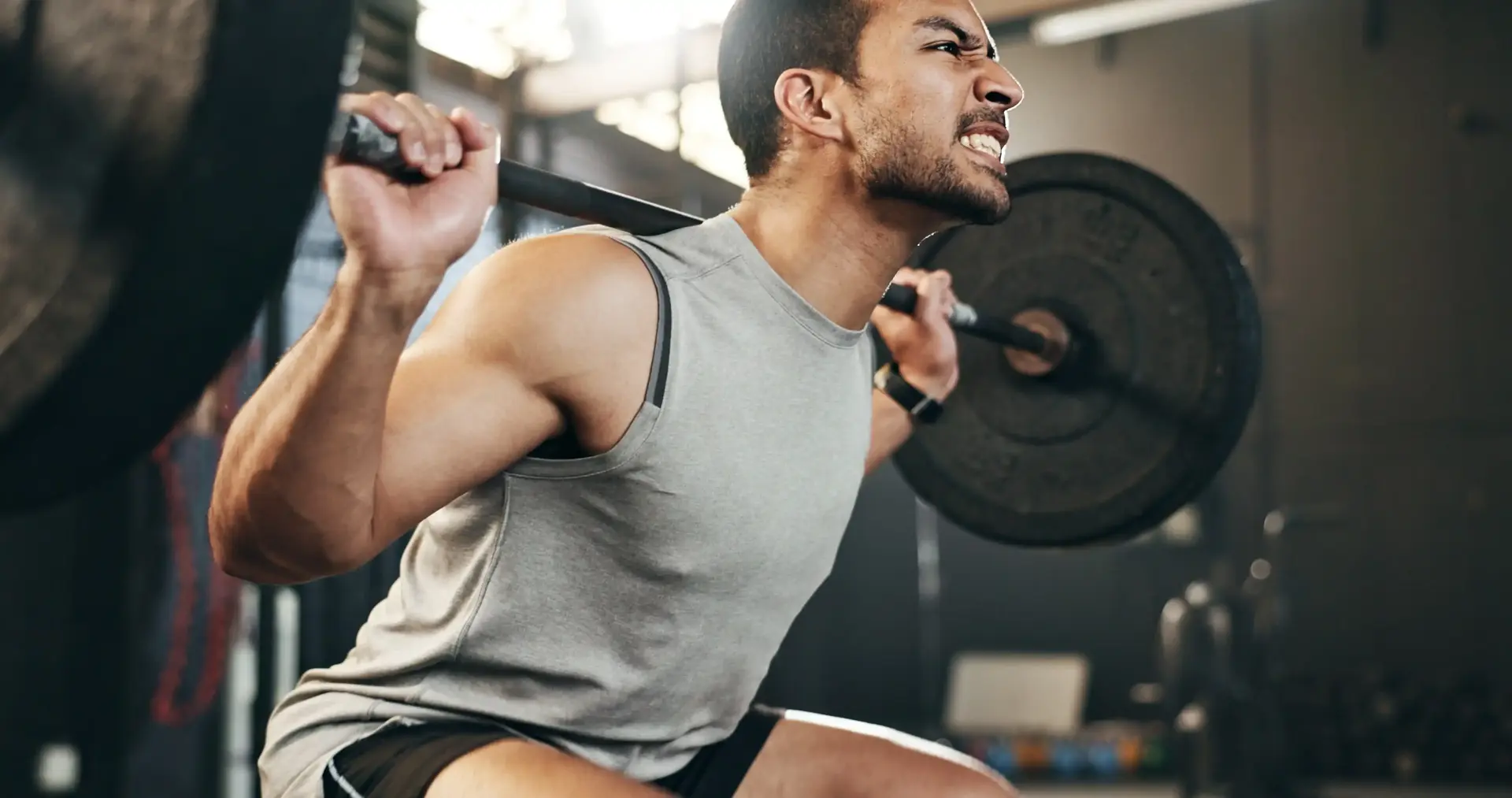 A man in a gym lifting weights.