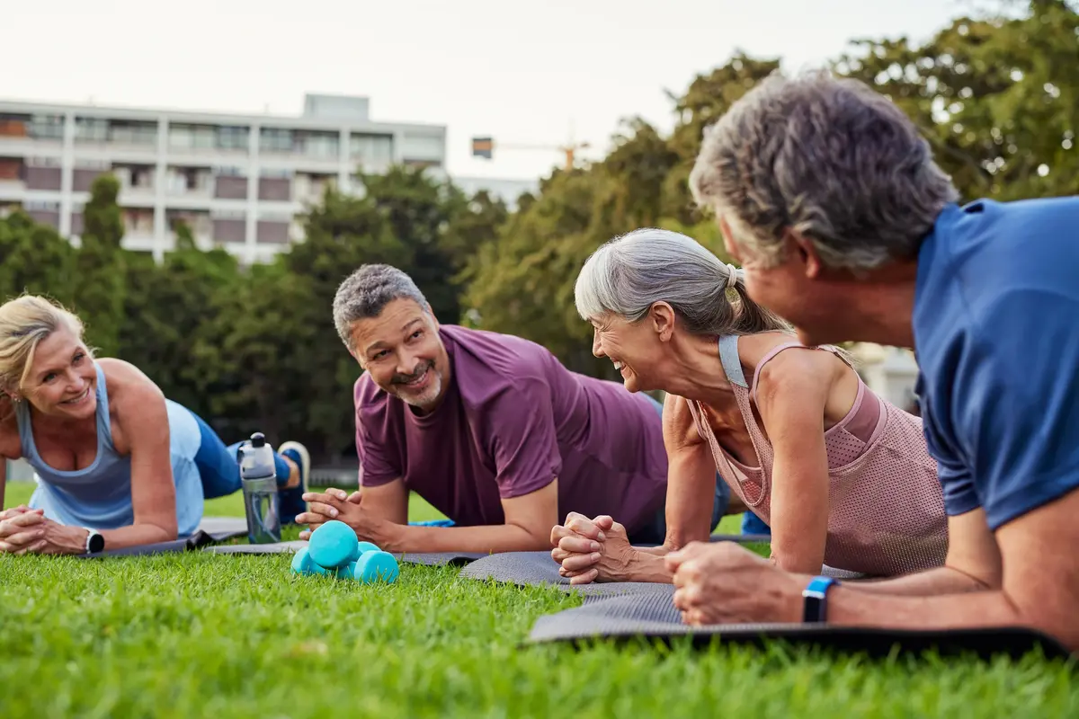 A group of seniors doing yoga in the park.