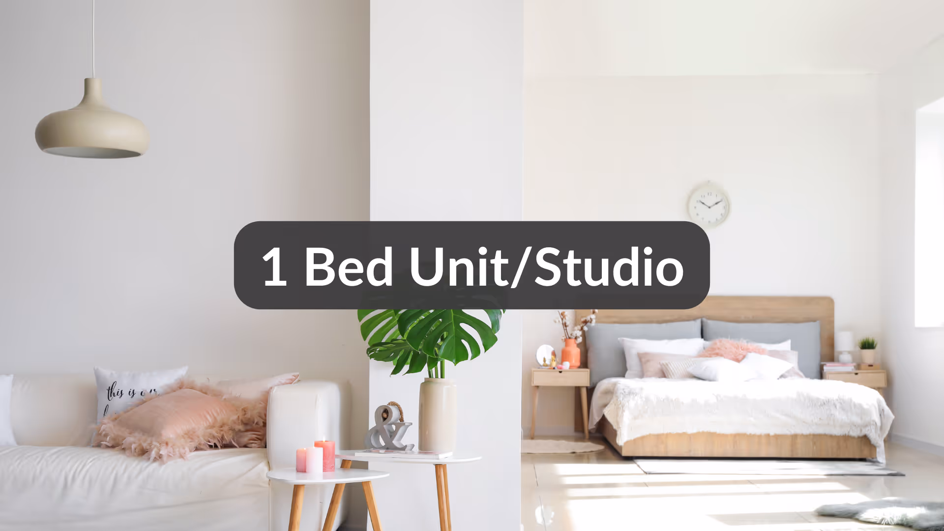 Bright, modern 1-bed studio apartment with a white sofa, pink cushions, two small tables with candles and a green plant, and a wooden bed with white and pink bedding.