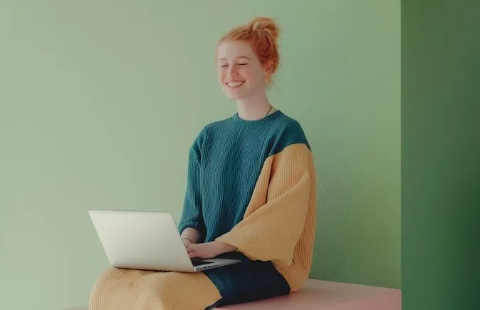 A woman sitting on a table using a laptop computer.