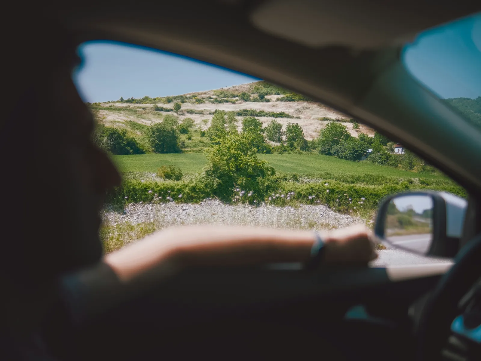 View from a car overlooking rolling countryside and fields, reflecting on-the-ground brand research for travel and place-based businesses.