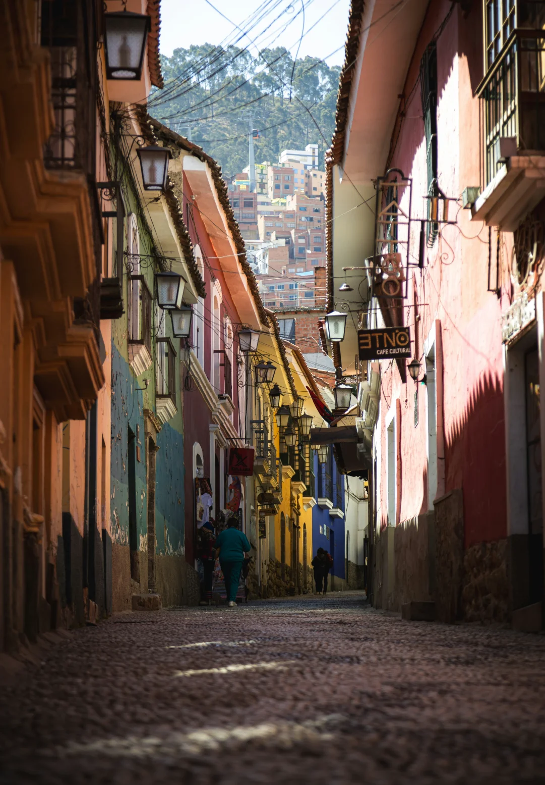 Colourful cobblestone street lined with historic buildings and cafés, capturing the atmosphere of a walkable tourism destination.