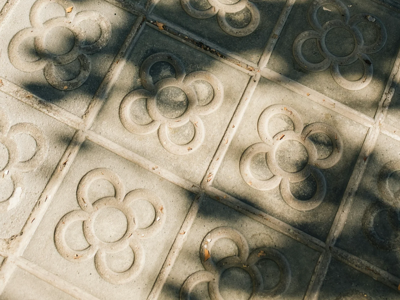 Decorative flower-pattern sidewalk tiles in soft sunlight, highlighting the small environmental details that shape memorable brand identity and sense of place.