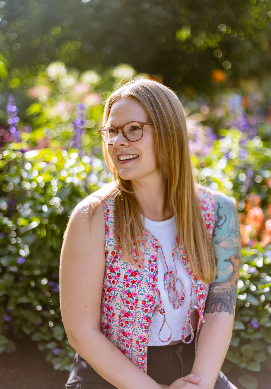 Portrait of a creative founder standing in a sunlit garden, reflecting the personal, relationship-led approach behind a boutique branding studio.
