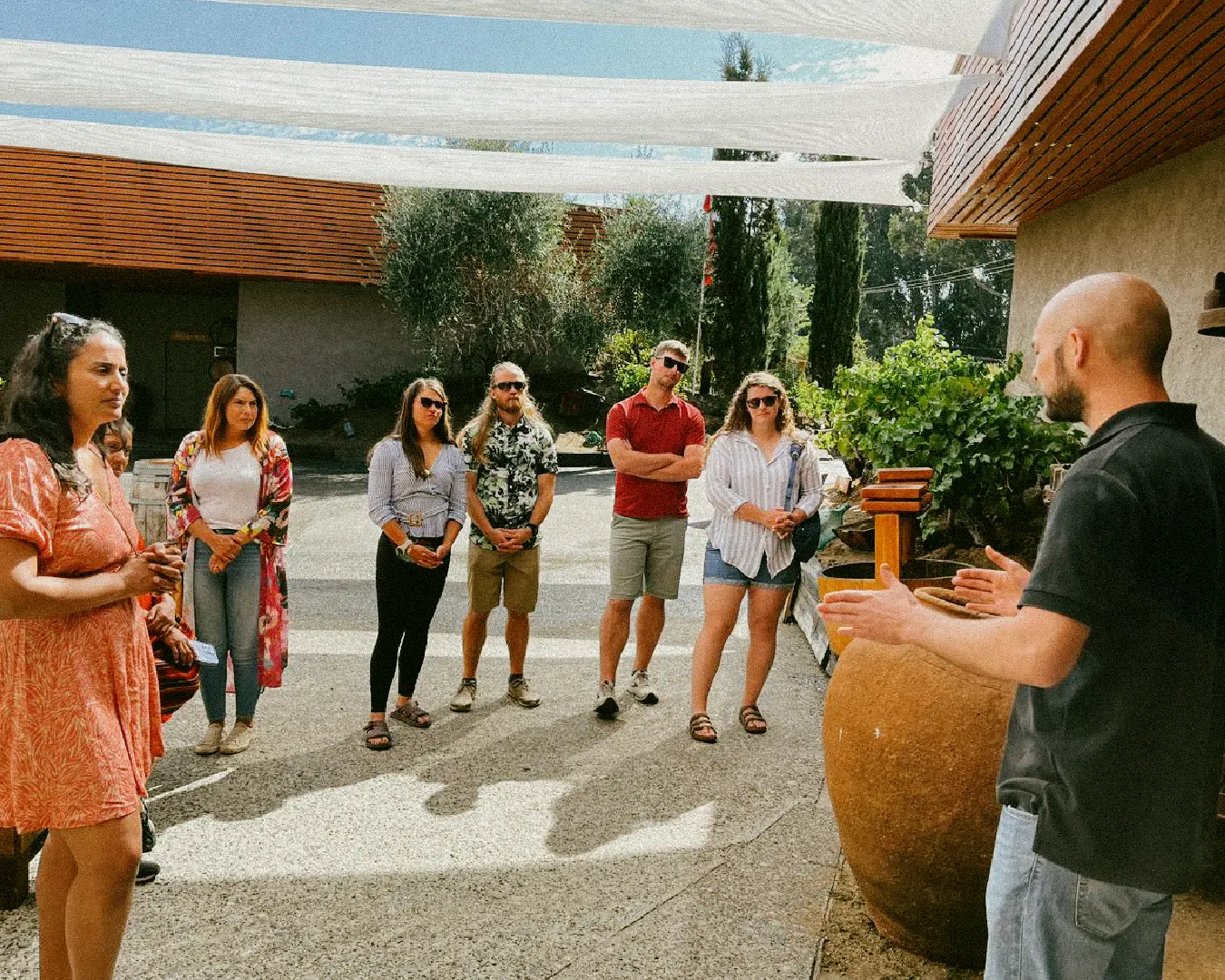 A Chile Off Track guide speaks to a small group of travellers in a winery courtyard, highlighting the brand’s personal, small-group hosting style.