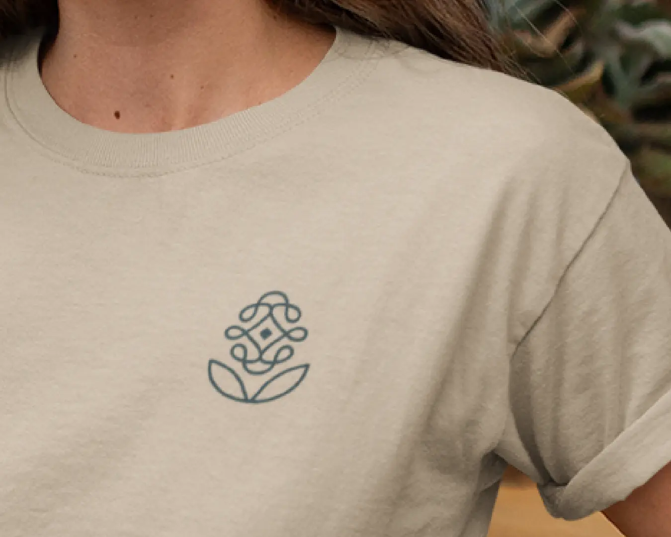 Close-up of a cream sweatshirt with the Reyou floral logo printed on the chest.