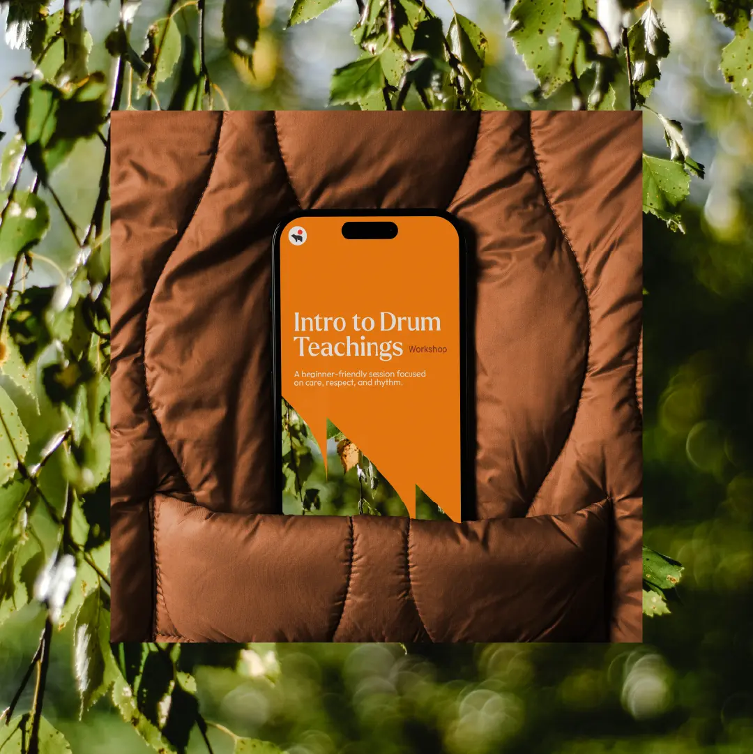 “Intro to Drum Teachings” workshop poster displayed on a phone, using orange and green brand graphics.