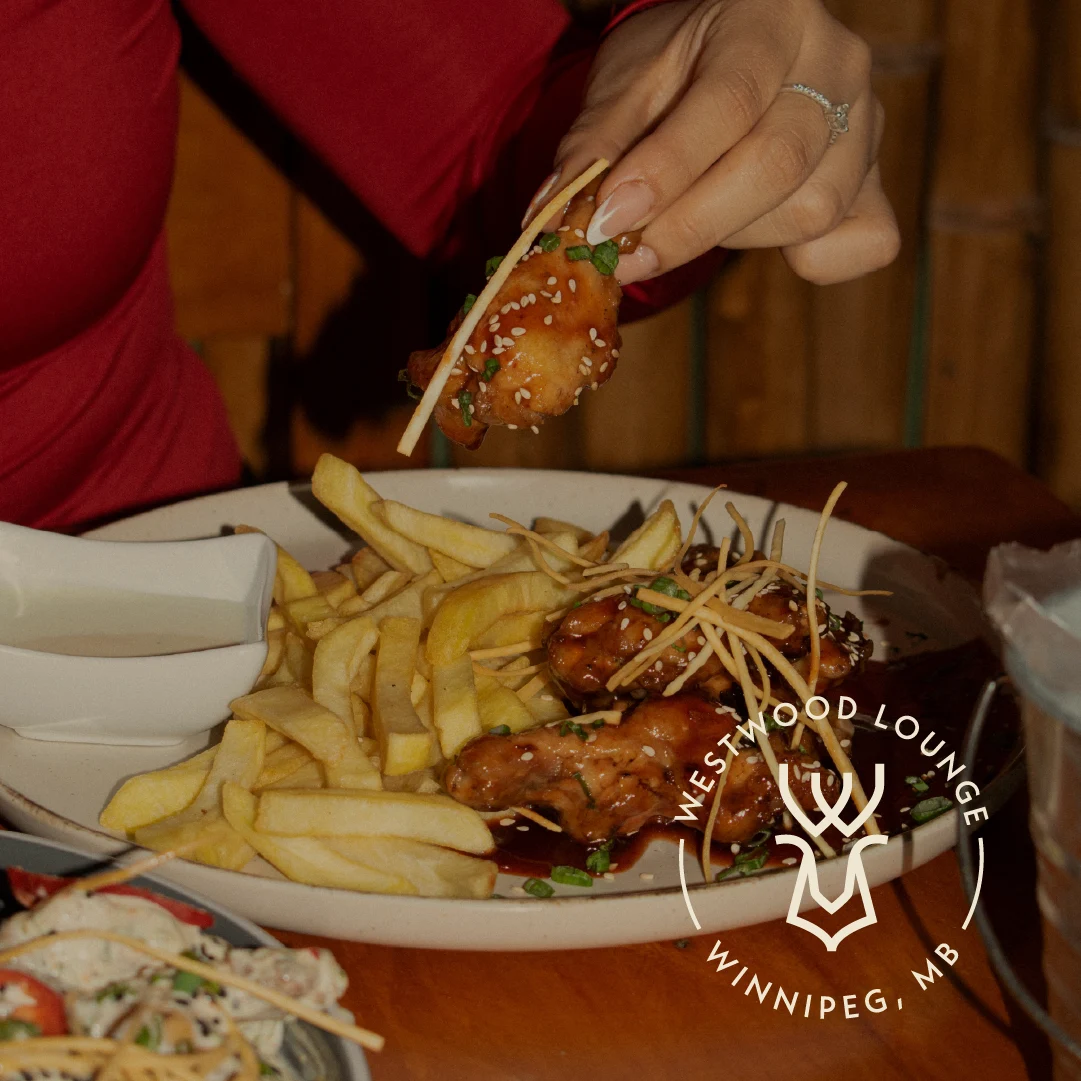 Plate of wings and fries at Westwood Lounge with the cocktail lounge logo overlaid.