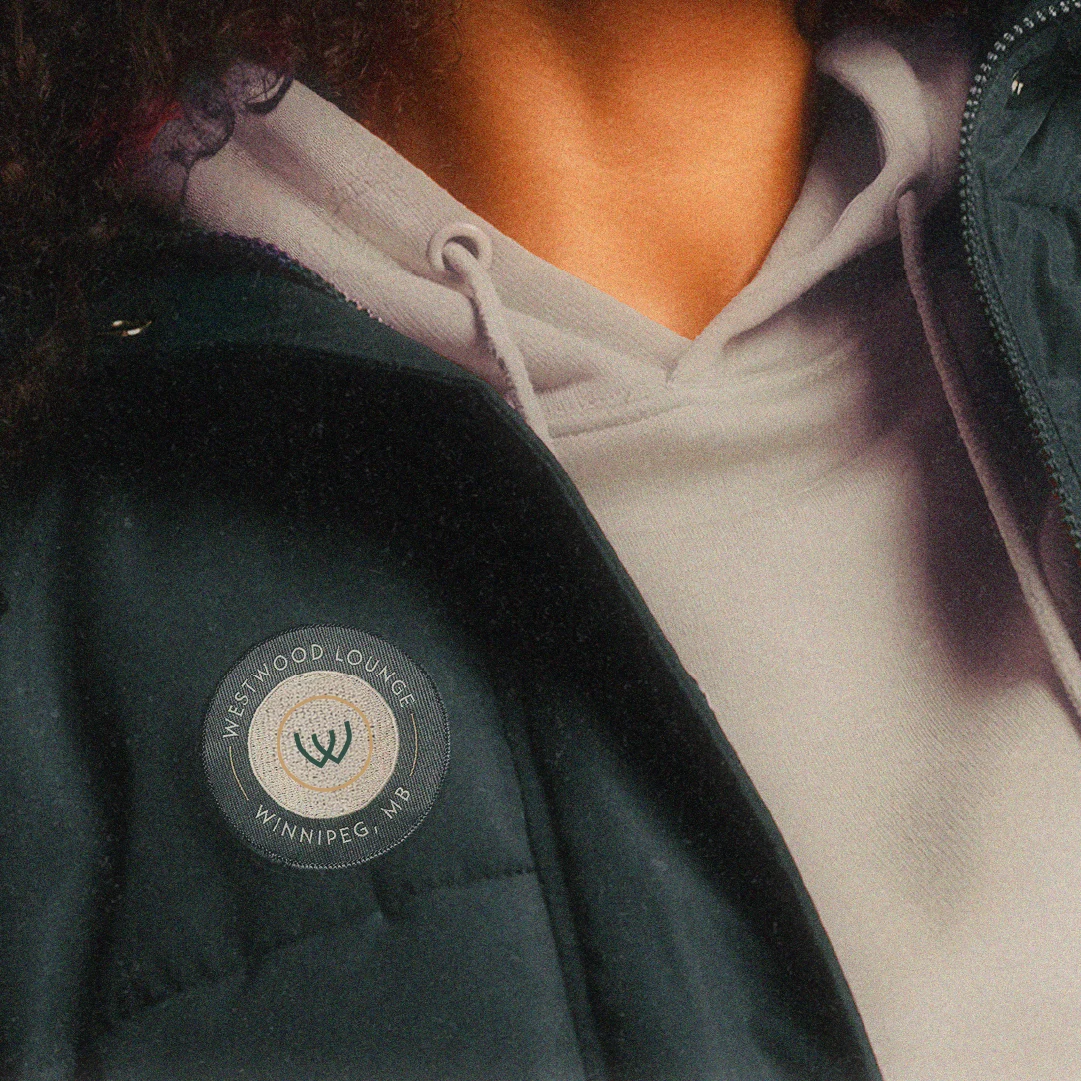 Close-up of a Westwood Lounge branded patch on apparel with circular logo and Winnipeg location detail.