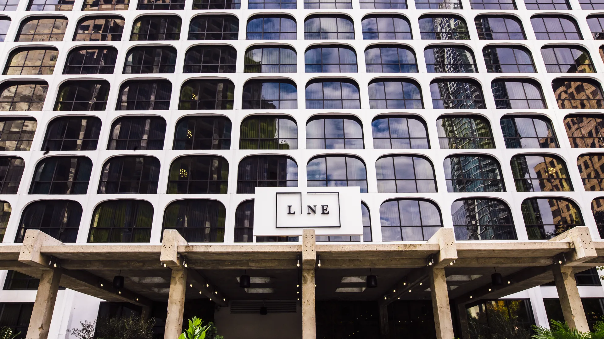 Exterior of The LINE Austin hotel with a white geometric façade and entrance signage.