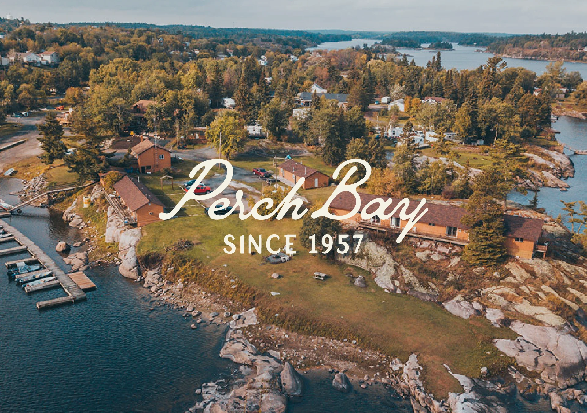 Aerial view of Perch Bay Resort’s waterfront cabins and rocky shoreline in Northern Ontario, with the Perch Bay Since 1957 logo.