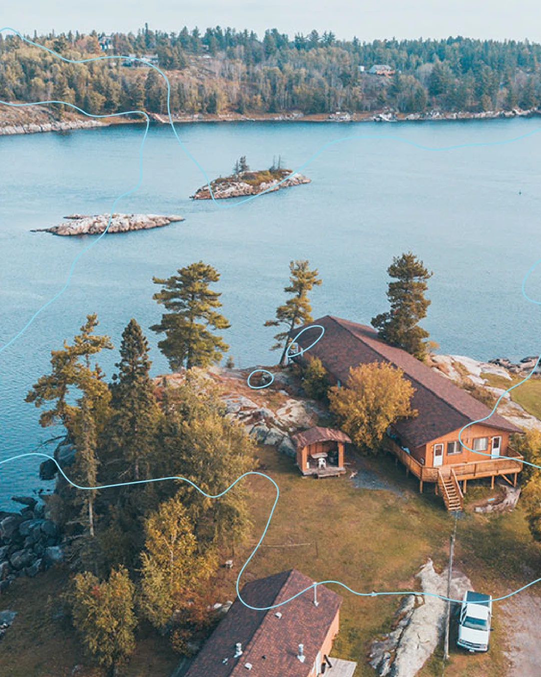 Aerial view of Perch Bay Resort cabins along the rocky waterfront, overlaid with pale blue lines inspired by the Winnipeg River.