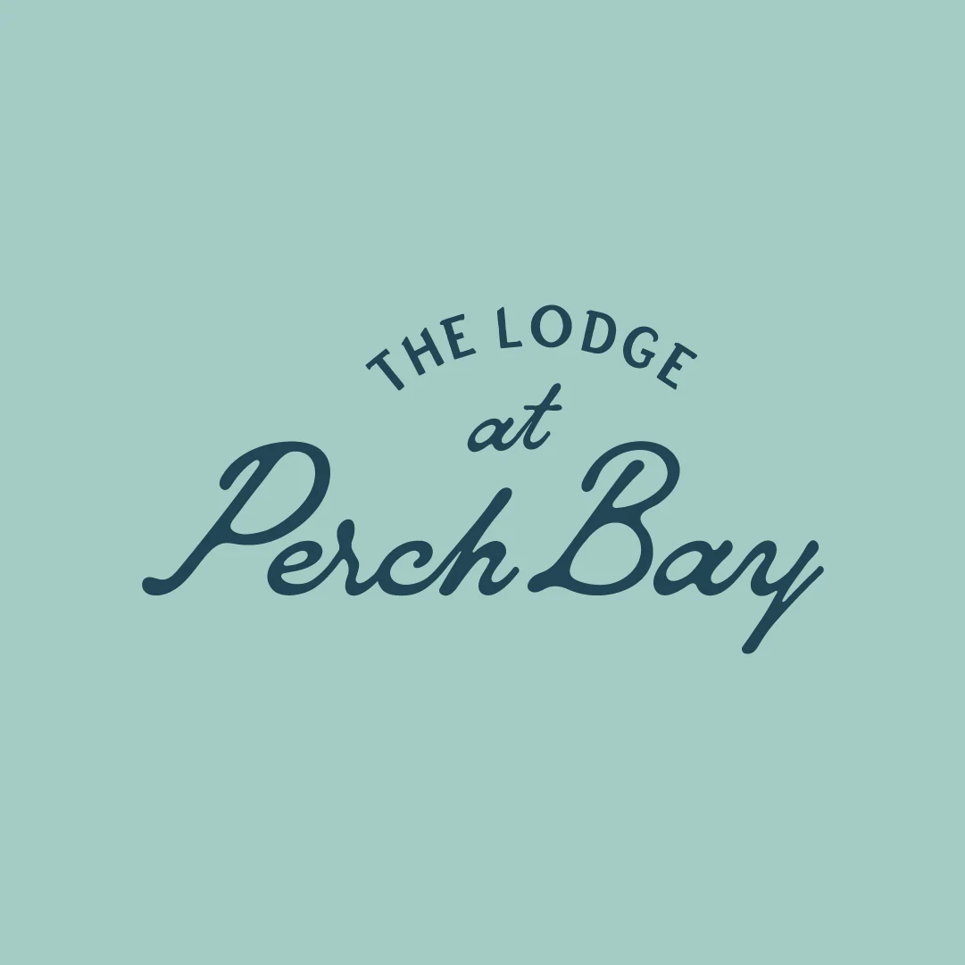 Navy The Lodge at Perch Bay logo centred on a pale blue background.