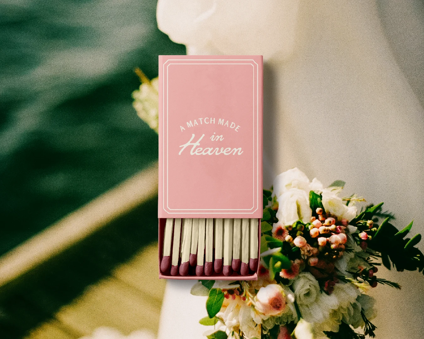 Pink wedding matchbox reading “A Match Made in Heaven” displayed on a floral arrangement for The Lodge at Perch Bay.