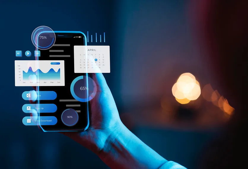 Hand holding a smartphone displaying digital interface with charts, calendar, and progress circles in a blue-lit environment.