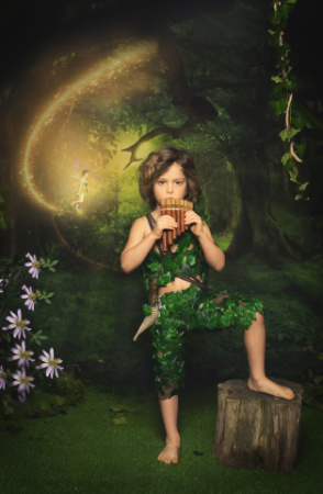 Bambino a piedi nudi su ceppo che suona il flauto di Pan in ambientazione fiabesca ispirata a Peter Pan.