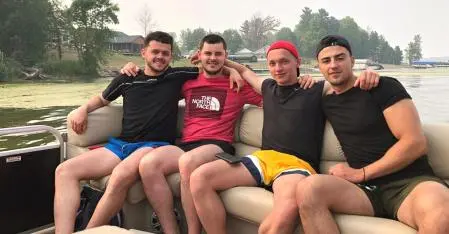 four friend on a boat at the lake