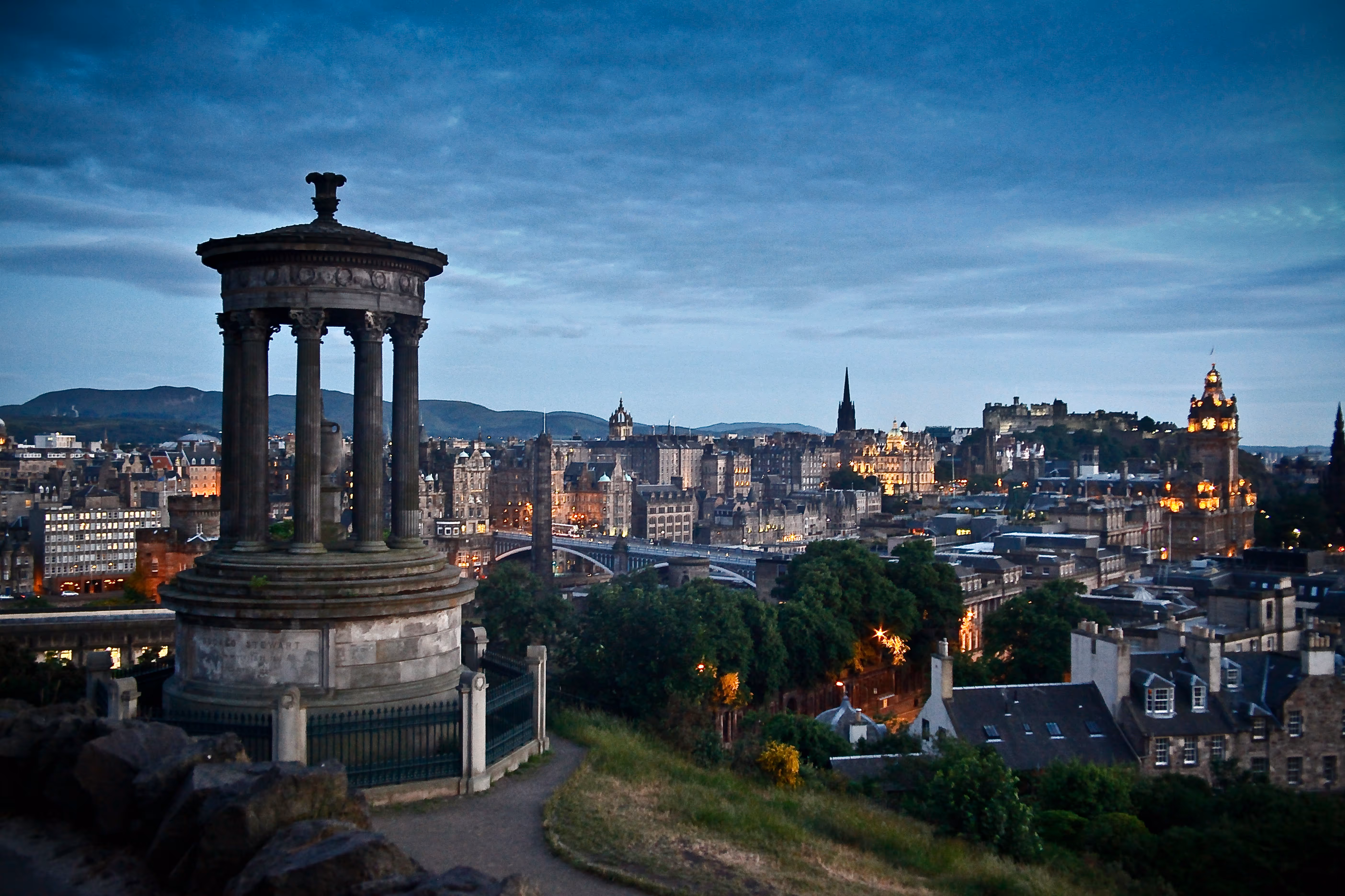 A picture of a tower on a hill overlooking a city
