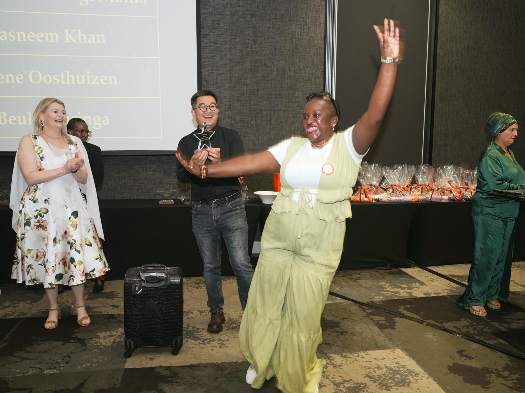 A joyful award recipient celebrates on stage at Rise Together