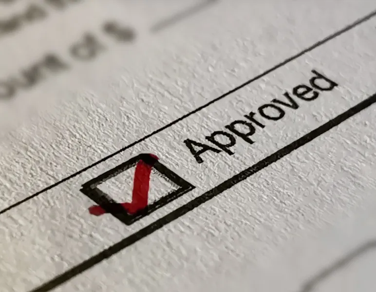 A paper with a green check mark, indicating approval or completion.