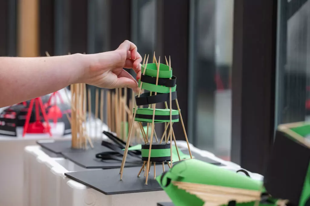 Student completing an engineering project, using toothpicks to build a structure