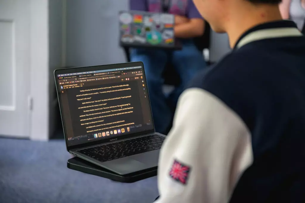 Student reading literature on their laptop