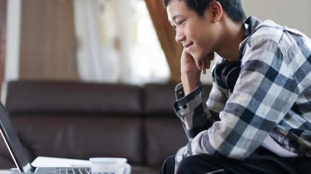 A student attending an online class using their laptop