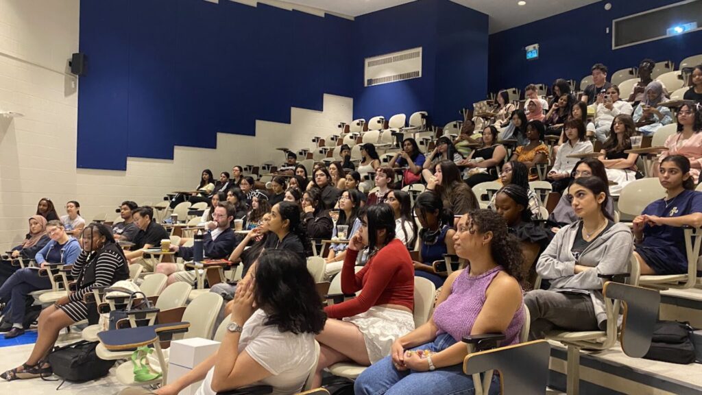 Students sitting in a classroom and listening to the instructor.