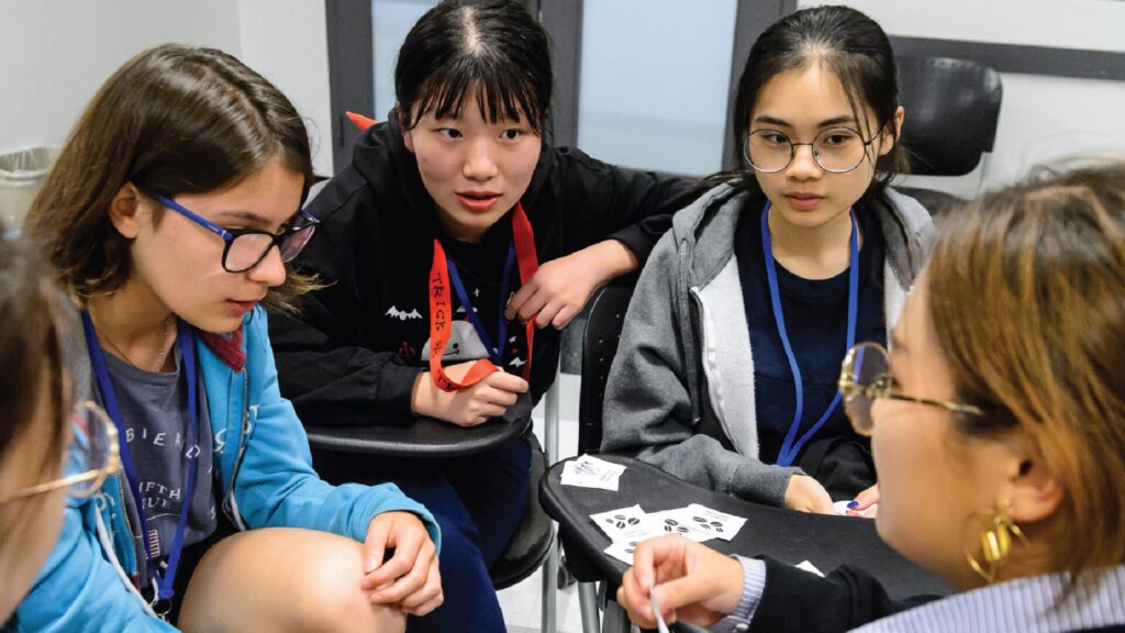 A group of students sitting in chairs in a circle and discussing something