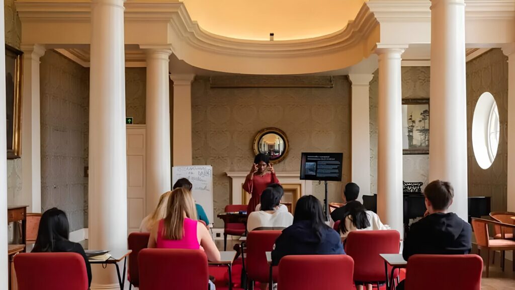A group of students attending a law class in a classroom with pillars