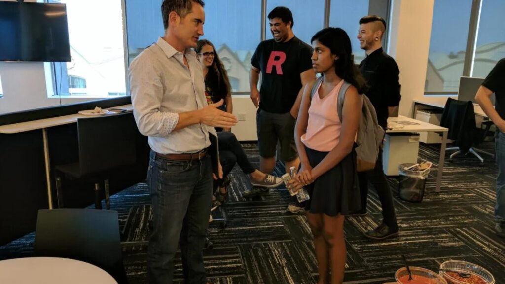 A participant conversing with a professional during a field trip, gaining insight into entrepreneurship