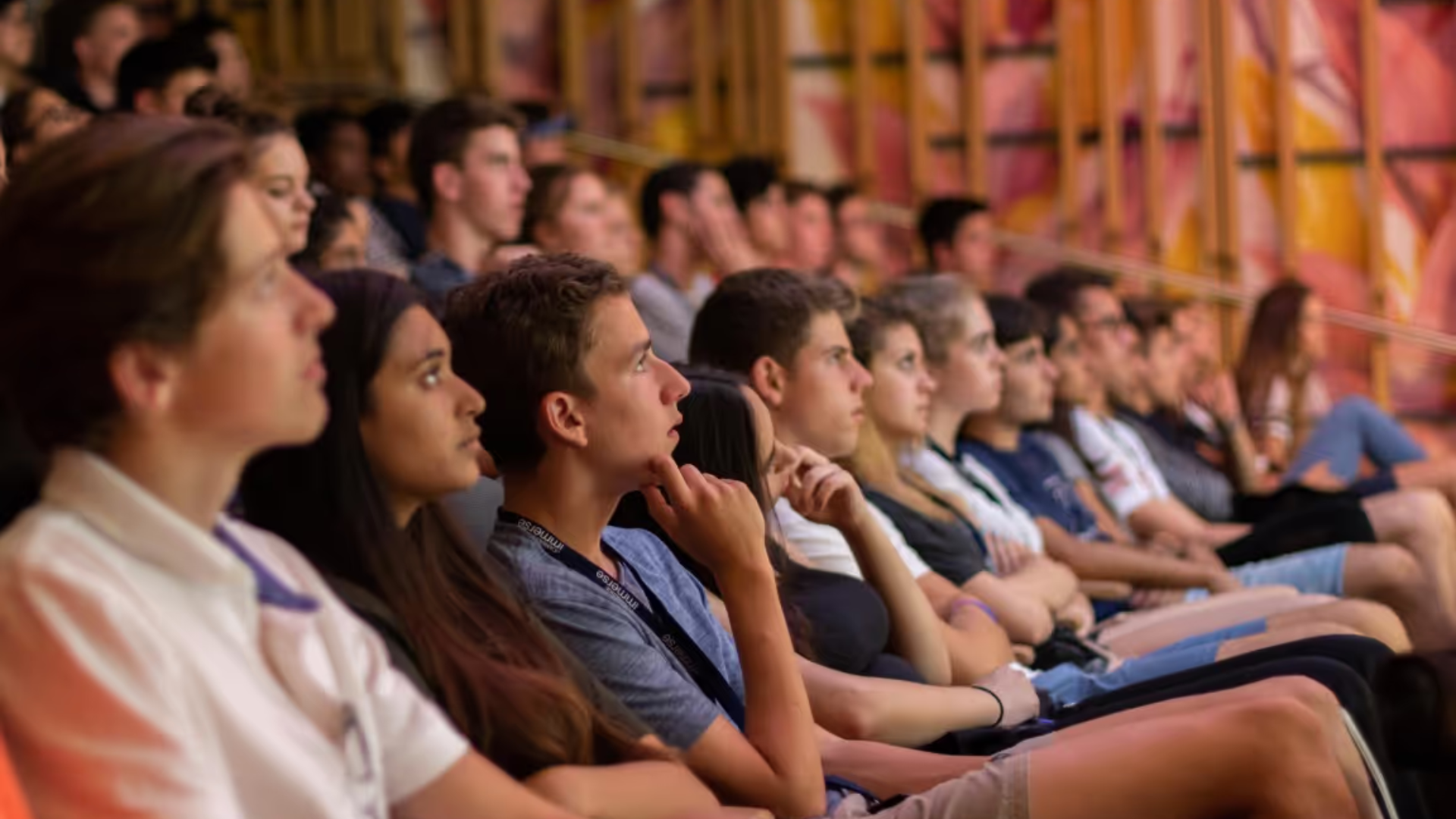 A group of students sitting in a lecture hall and listening attentively