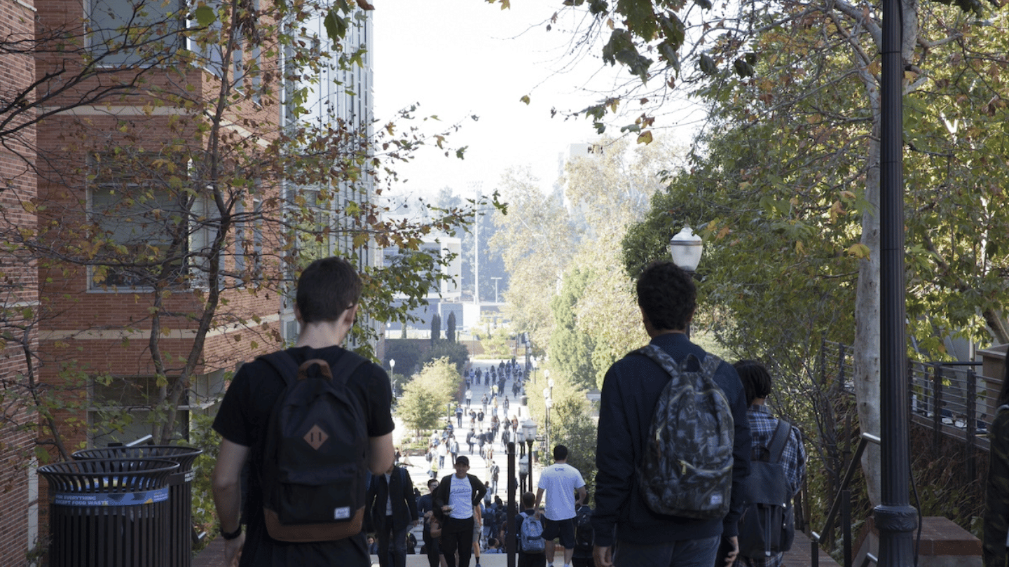 Two students standing with backpacks slung over their shoulders