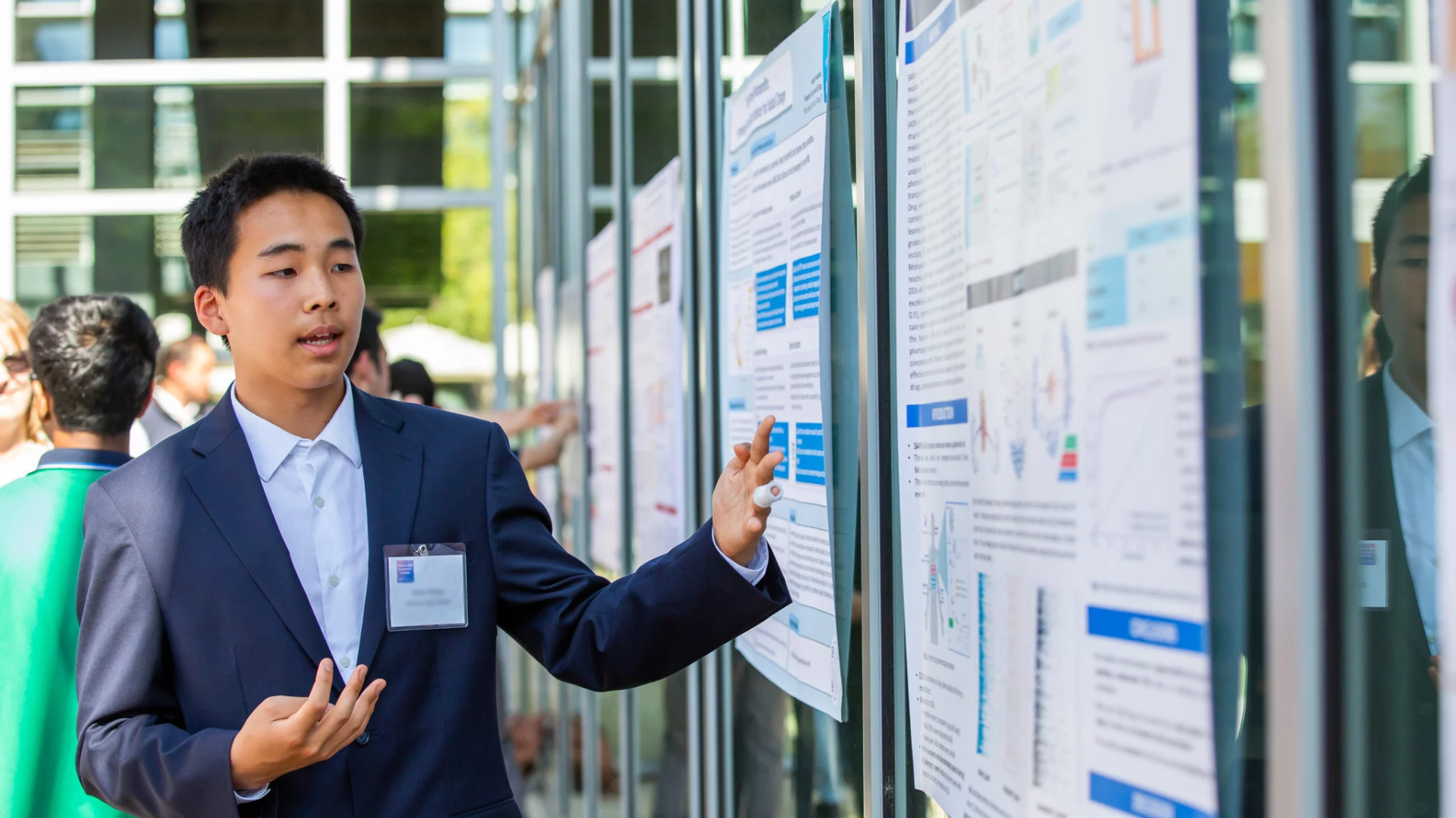 A student presenting a poster as a part of a poster presentation event