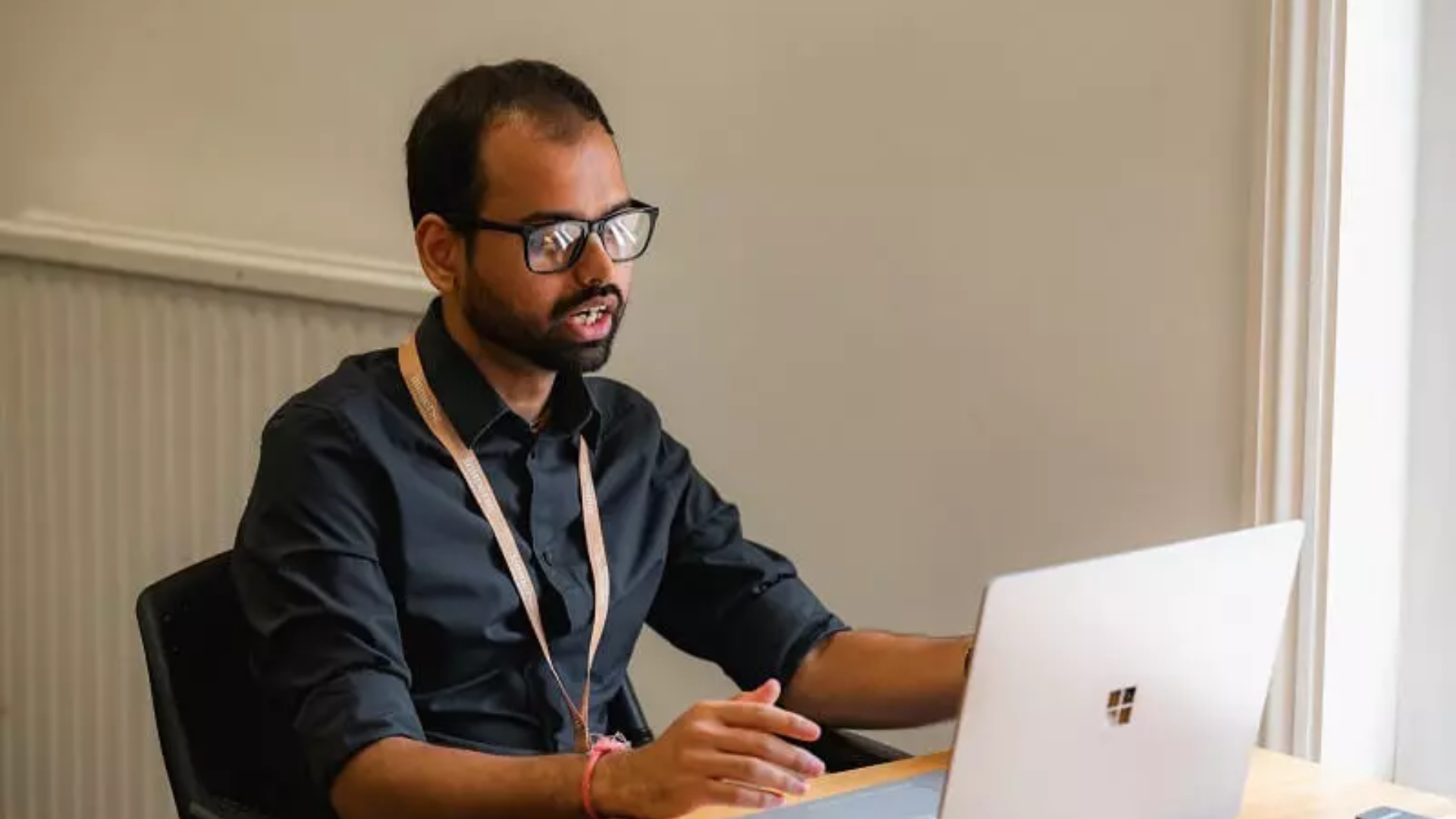 A person saying something while attending an online class on their laptop