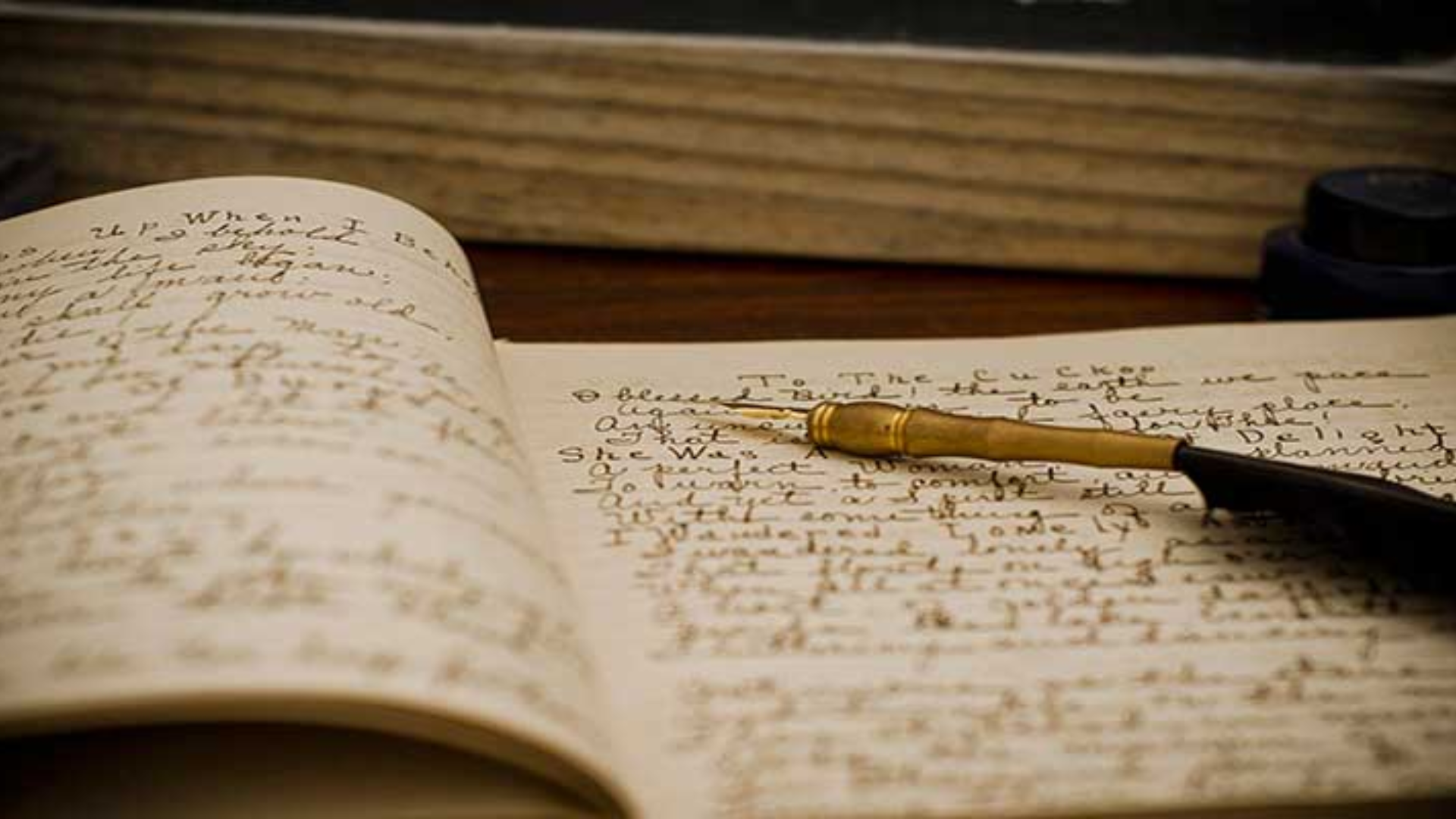 An open notebook, with a pen lying on top of it