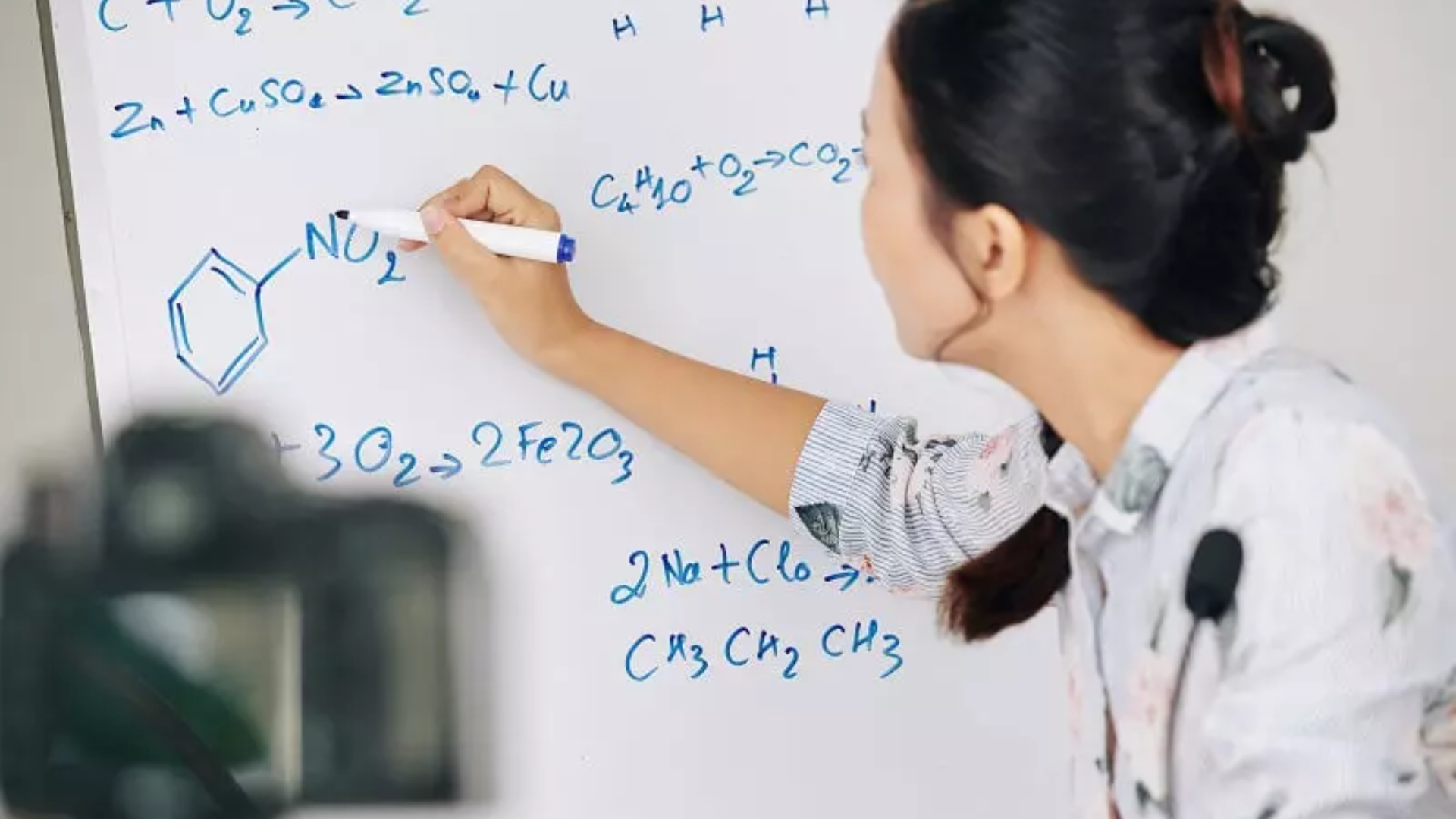 A faculty member teaching chemistry on a whiteboard at Immerse's summer school.
