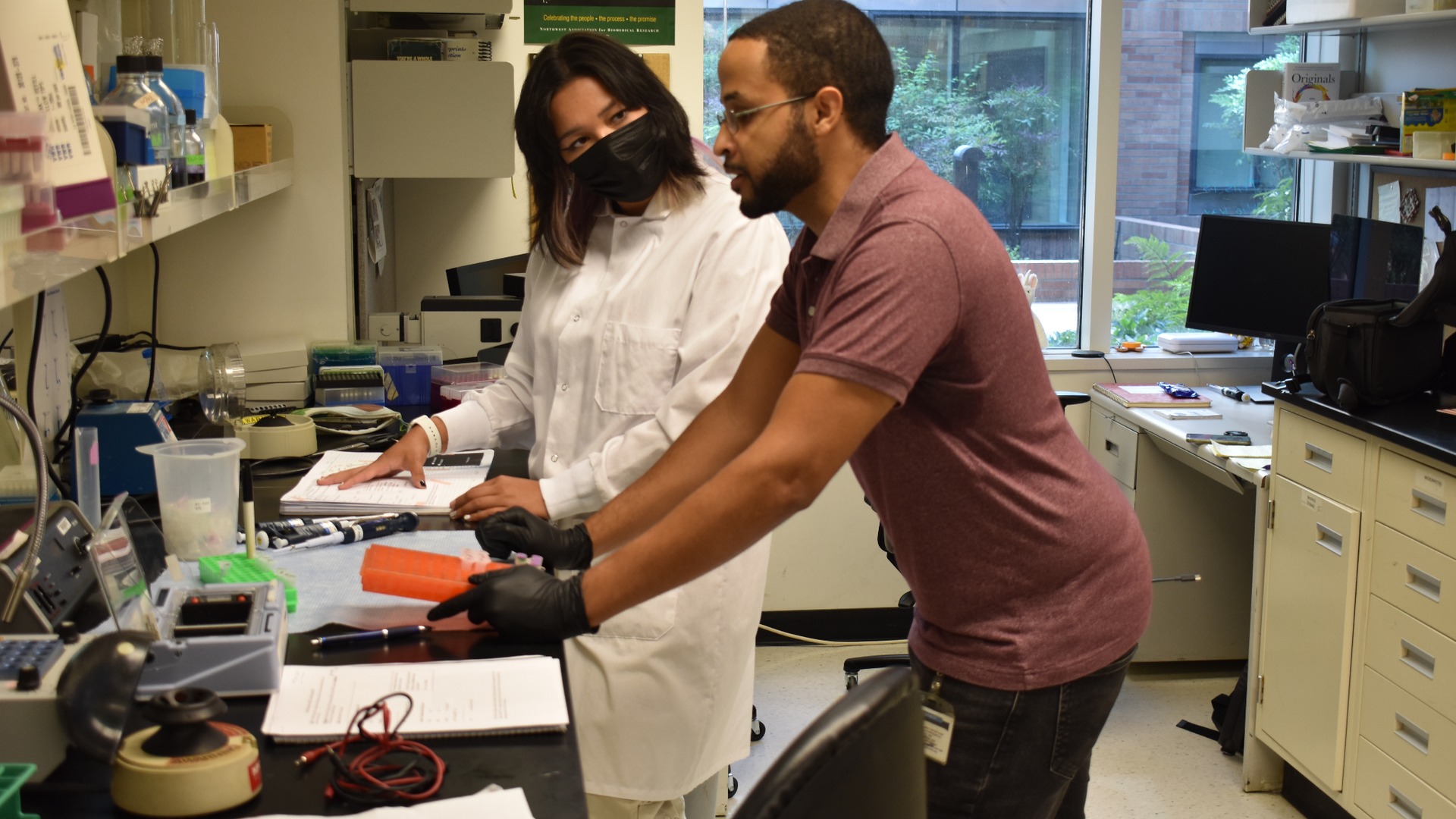 Two people standing in a laboratory and talking.