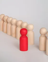 Red wooden figure standing out among beige figures