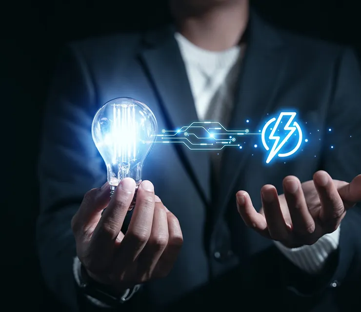 Businessman holding glowing light bulb with energy symbol