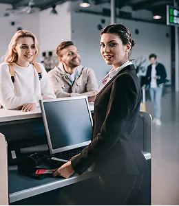 Smiling airline staff assisting passengers at check-in counter