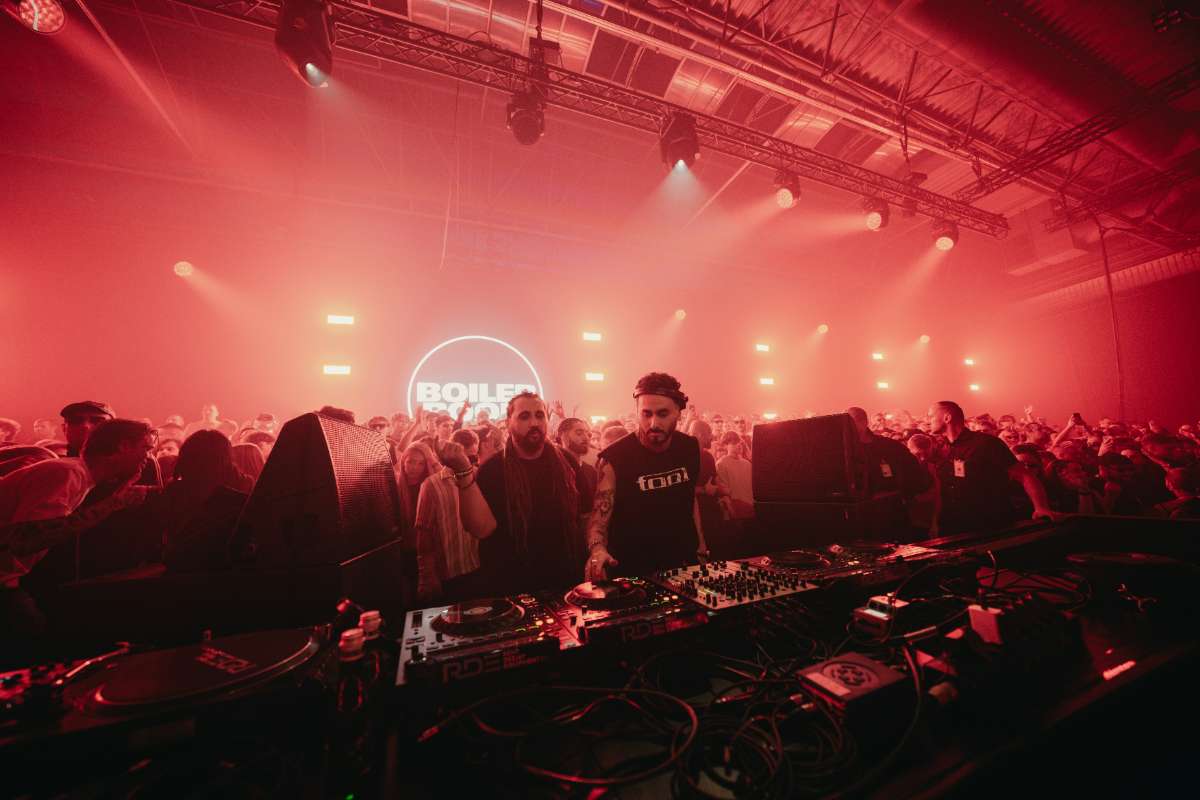 dj playing in a nightclub lit up by red lights