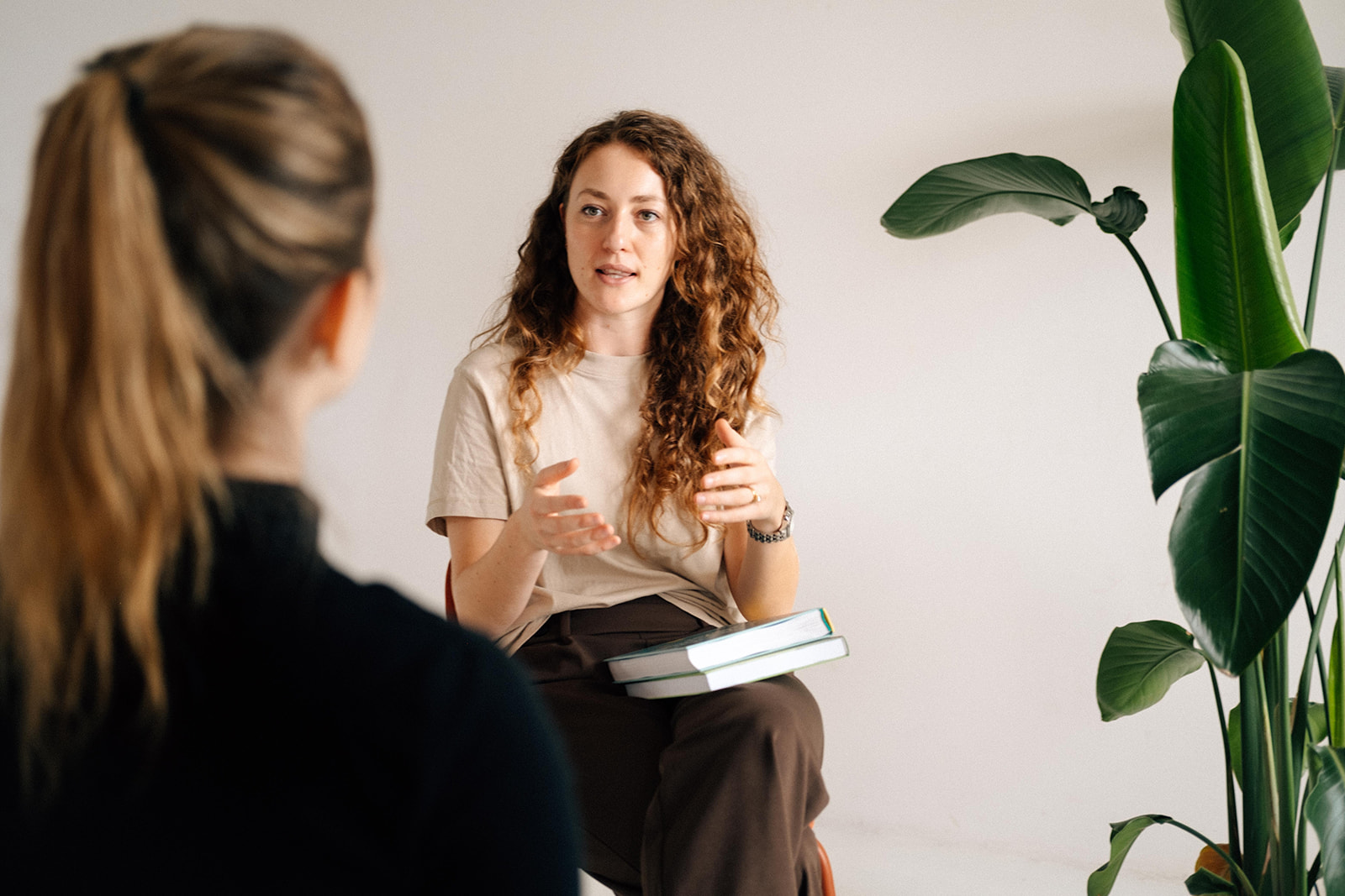 Eine Ernährungsberaterin berät eine Patientin. Sie sitzen sich gegenüber. die Patientin sitzt mit dem Rücken zur Kamera.