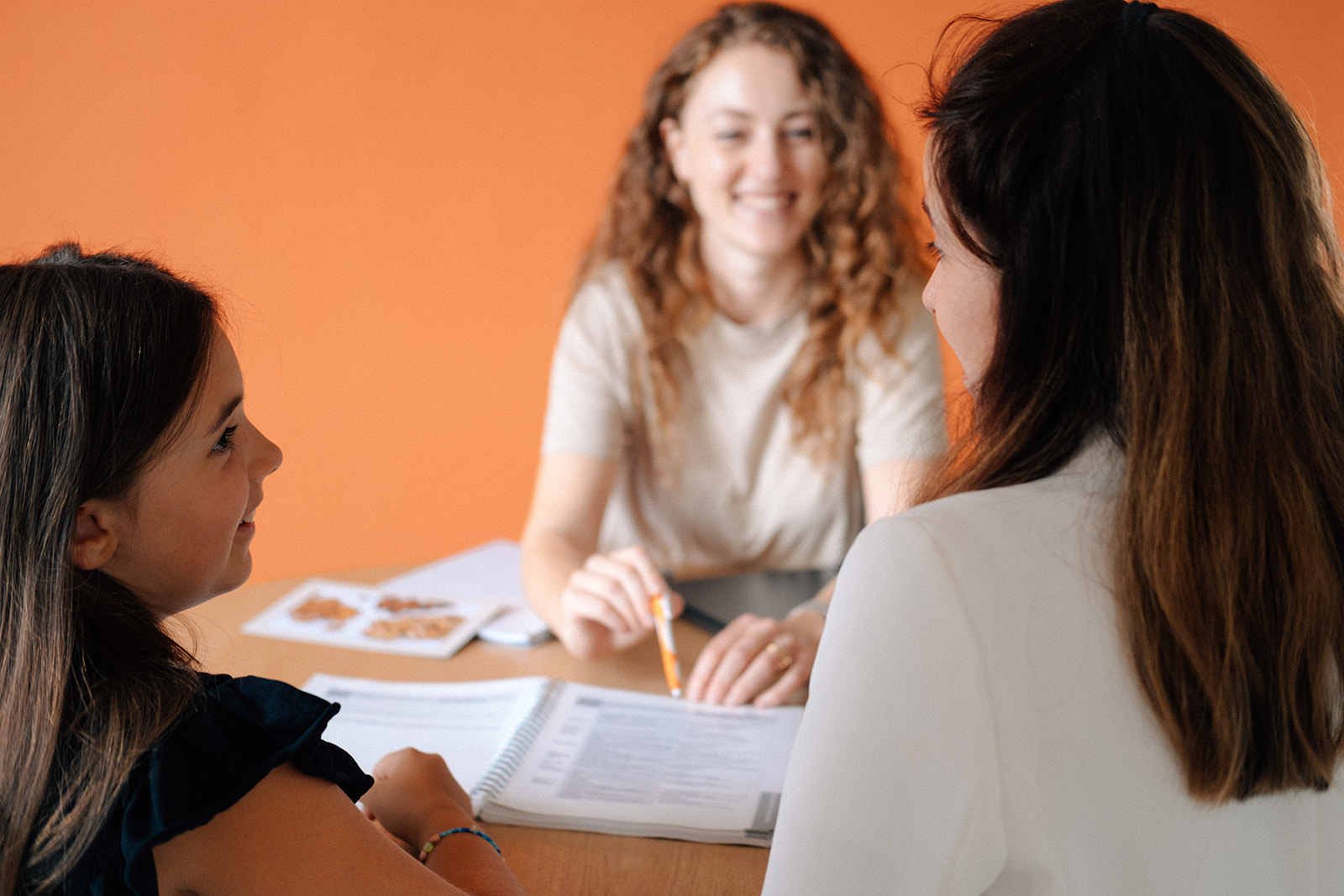 Eine Ernährungsberaterin berät lächelnd eine Mutter mit ihrem Kind.
