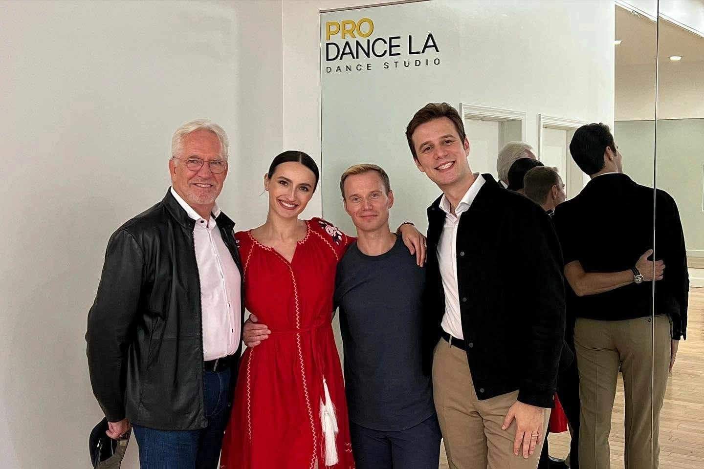 Dance lessons at Pro Dance LA studio: four smiling people pose together in front of the studio sign and a mirrored wall.