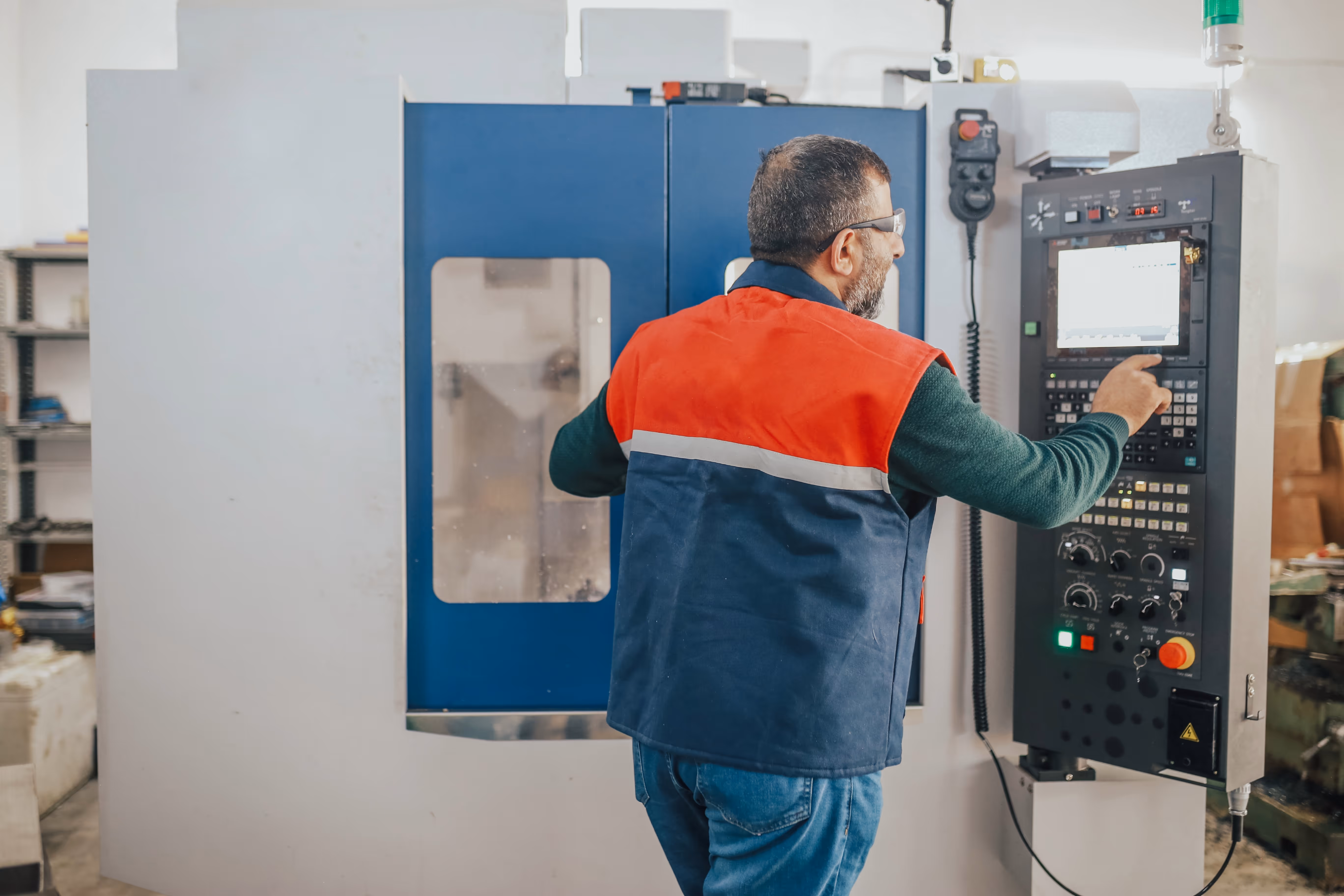 A man from Adaero Precision Components working on a CNC Machine